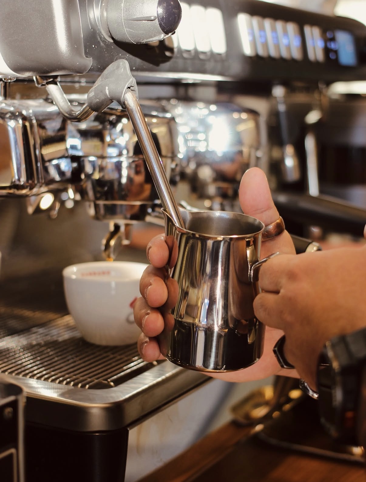 Barista monta il latte per il cappuccino