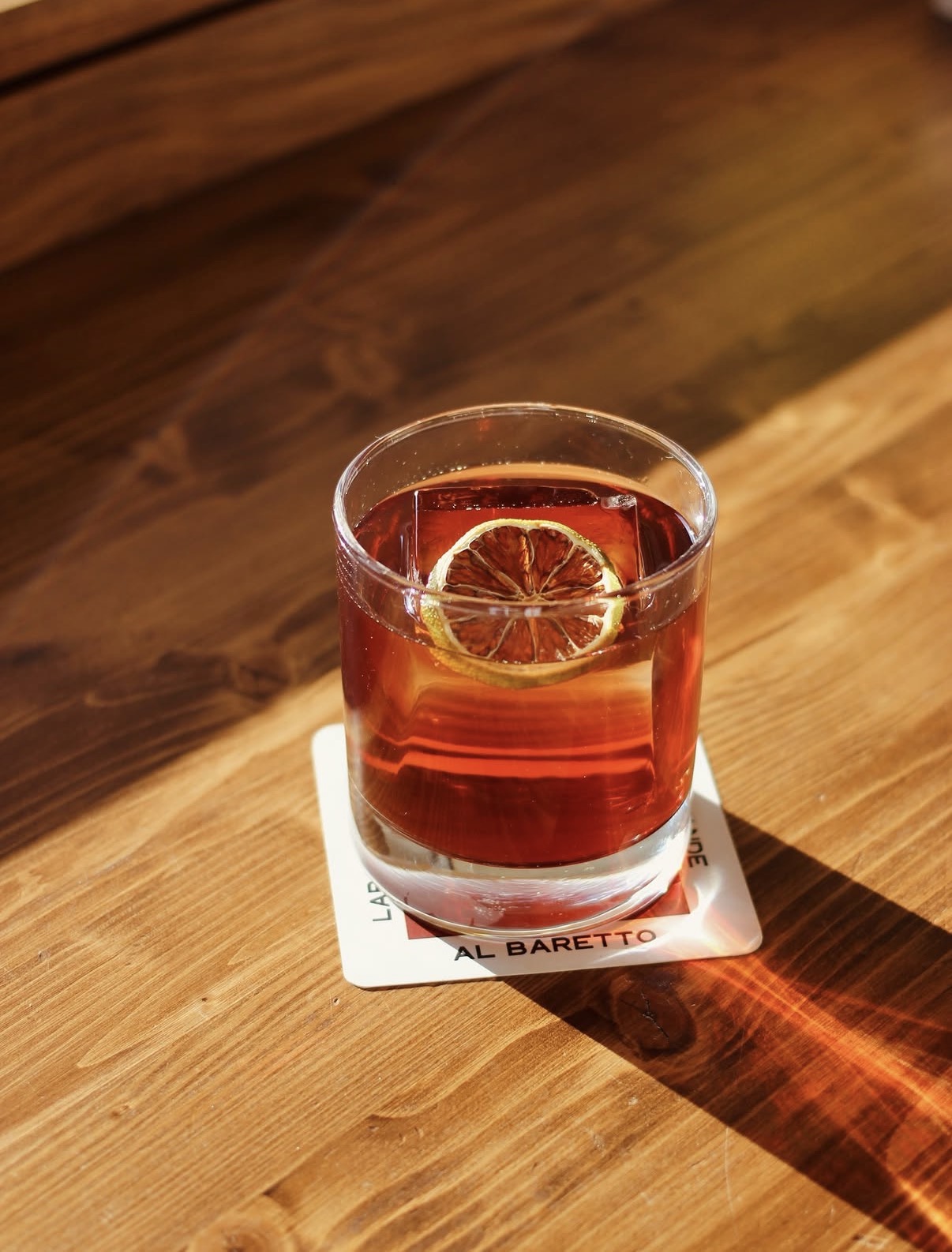 Negroni con arancia disidratata su tavolo in legno