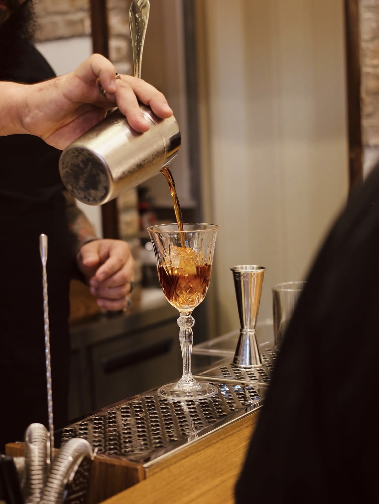 Bartender versa un cocktail in coppetta vintage